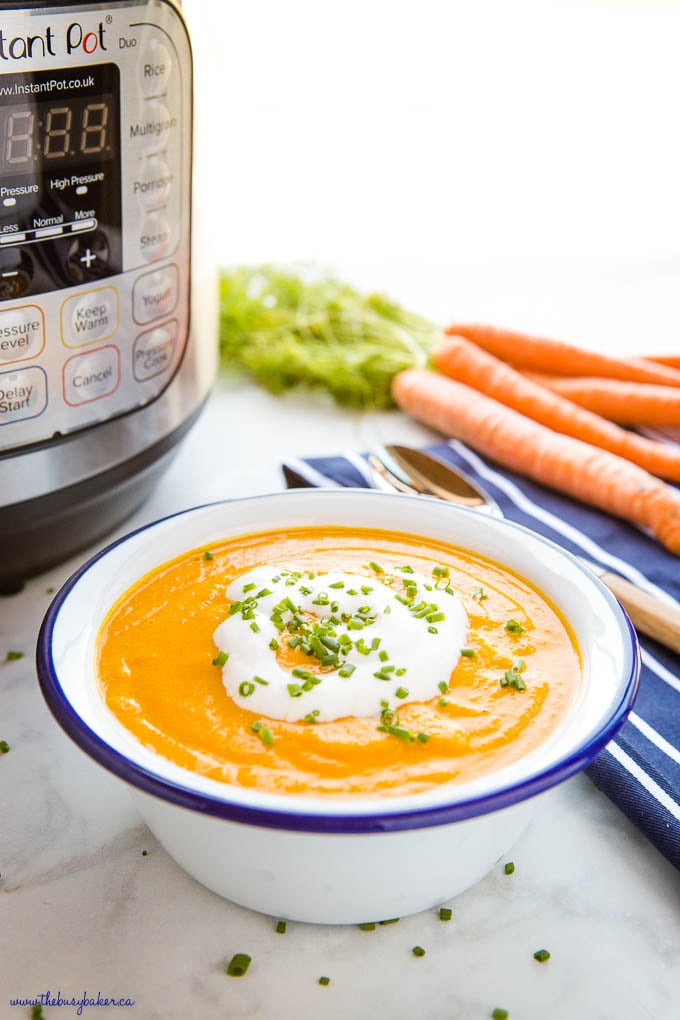 bowl of ginger carrot soup with coconut cream and chives