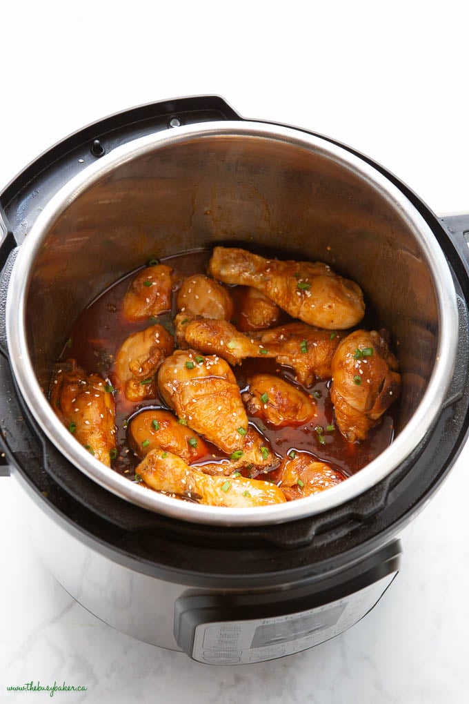 instant pot with honey garlic chicken drumsticks, with sesame seeds and green onions