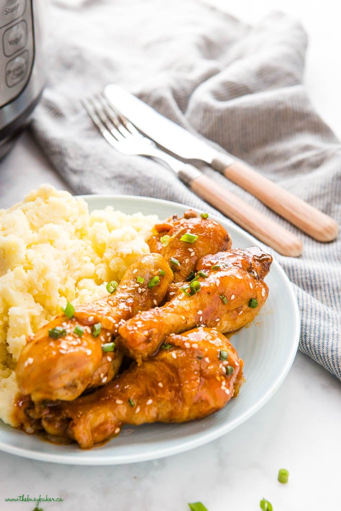 honey garlic chicken drumsticks on blue plate with mashed potatoes