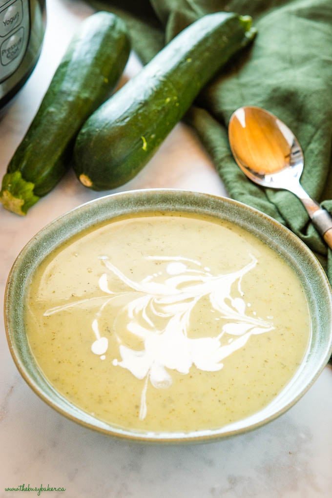 green bowl of instant pot zucchini soup with cream
