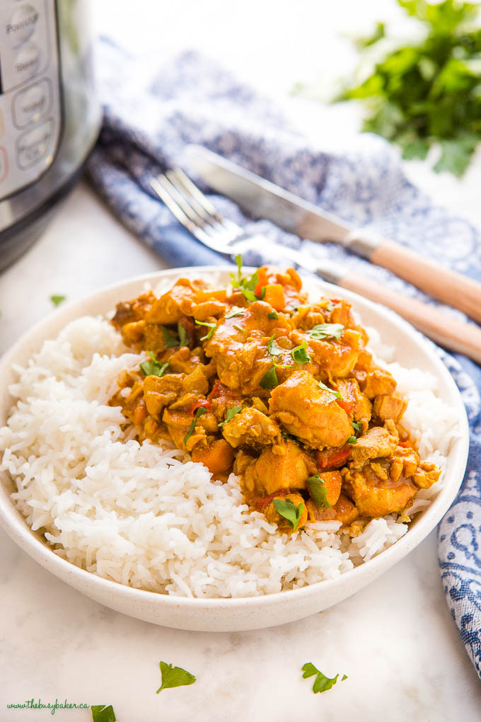butter chicken over rice in a white bowl