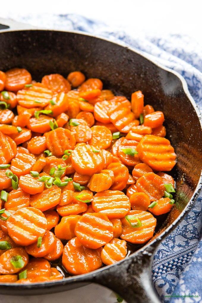cast iron pan with honey glazed crinkle cut carrots with green onions