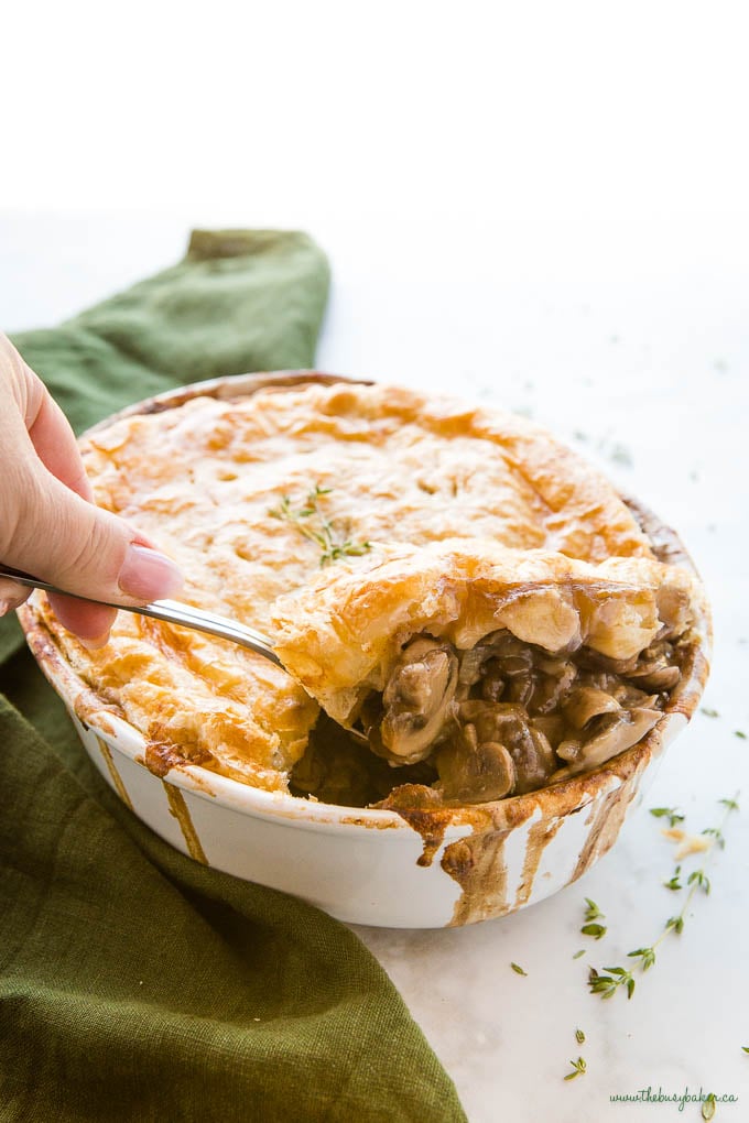 hand serving vegetarian mushroom pot pie