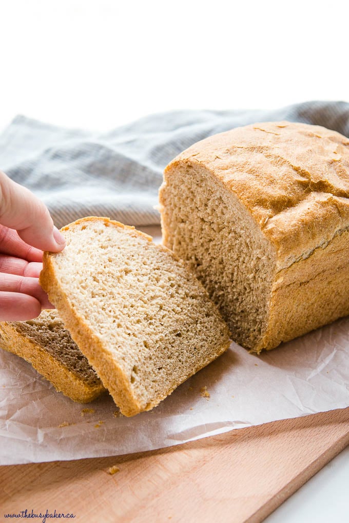 hand reaching for a slice of whole wheat bread