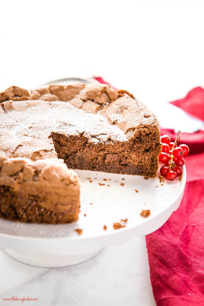 flourless chocolate cake on white cake stand