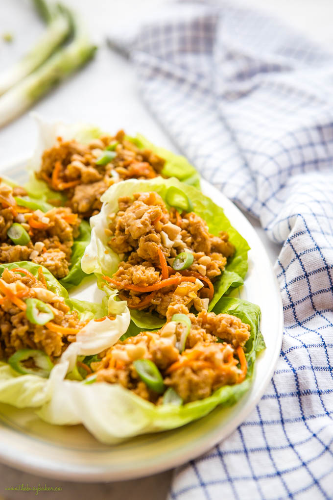 plate of thai chicken lettuce wraps beside blue checkered kitchen towel