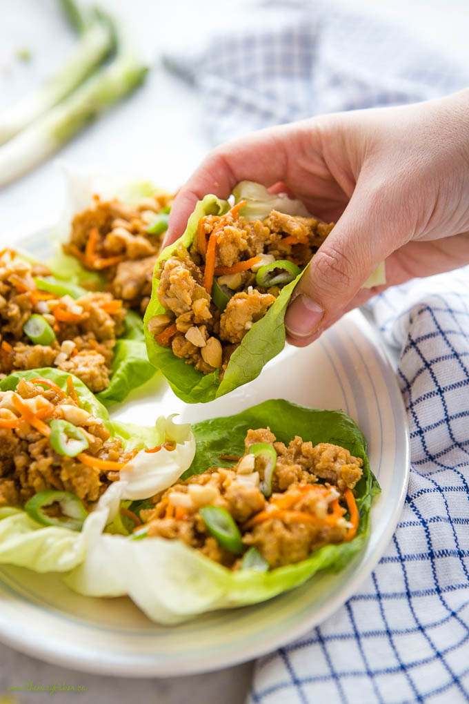 hand holding a low carb thai chicken lettuce wrap