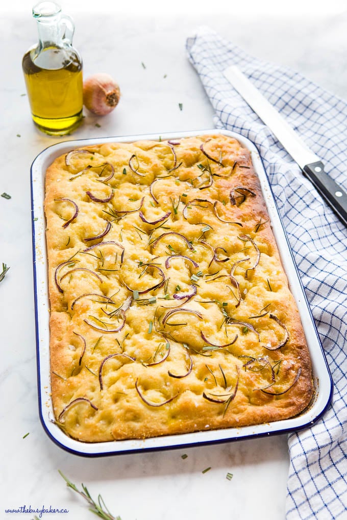 pan of focaccia bread with rosemary and red onions and olive oil