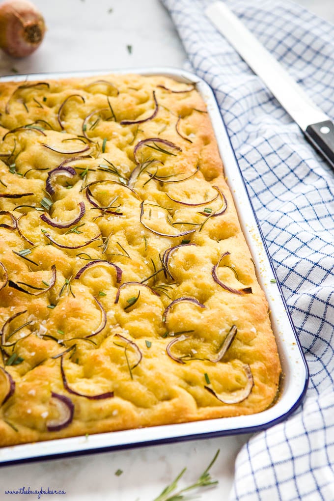 pan of rosemary focaccia bread in white pan with blue rim.