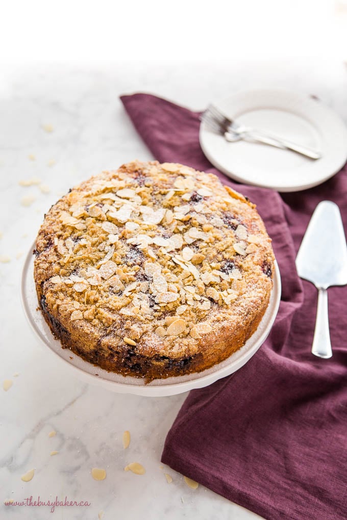 cherry almond coffee cake with sliced almonds on cake stand