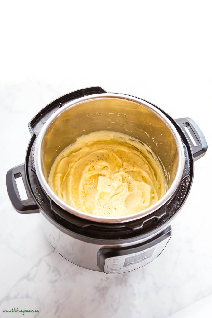 overhead image: Instant Pot with creamy mashed potatoes, butter and black pepper