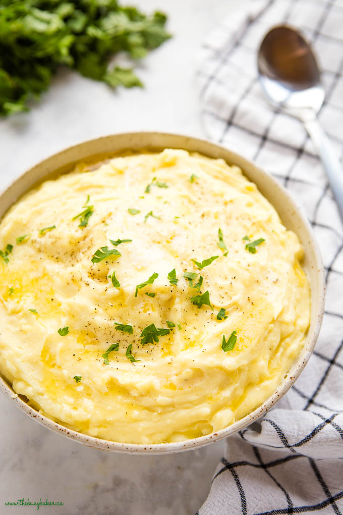 creamy mashed potatoes in bowl with melted butter and fresh herbs