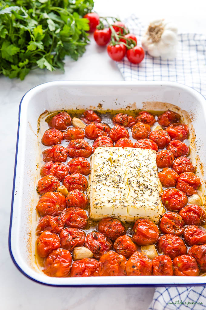 baked feta and cherry tomatoes in white pan with blue rim