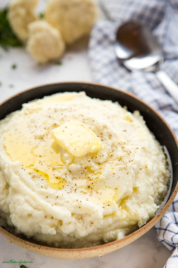 closeup image: bowl of cauliflower mashed potatoes with melted butter