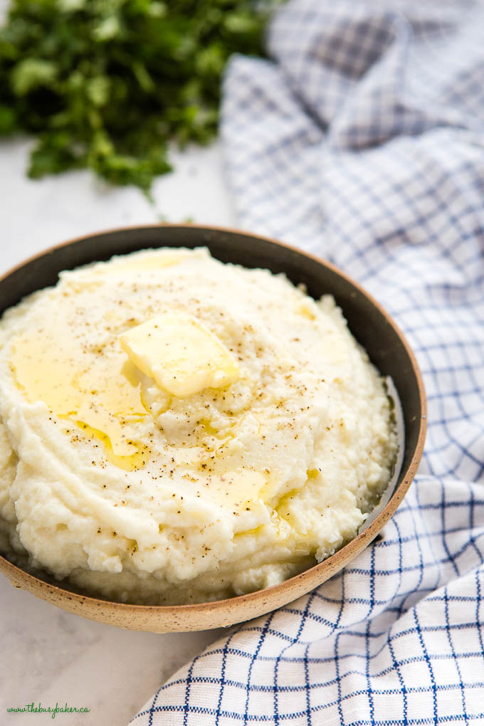bowl of low carb cauliflower mash with melted butter, salt and pepper