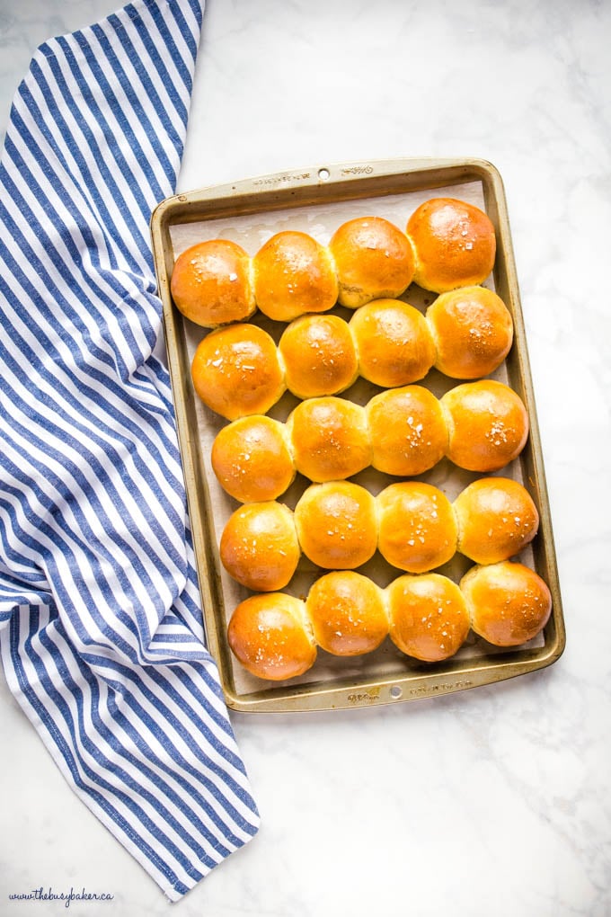 overhead image: pan of golden brown dinner rolls on marble countertop