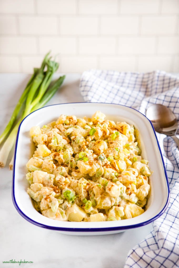 bowl of easy potato salad in white bowl with green onions