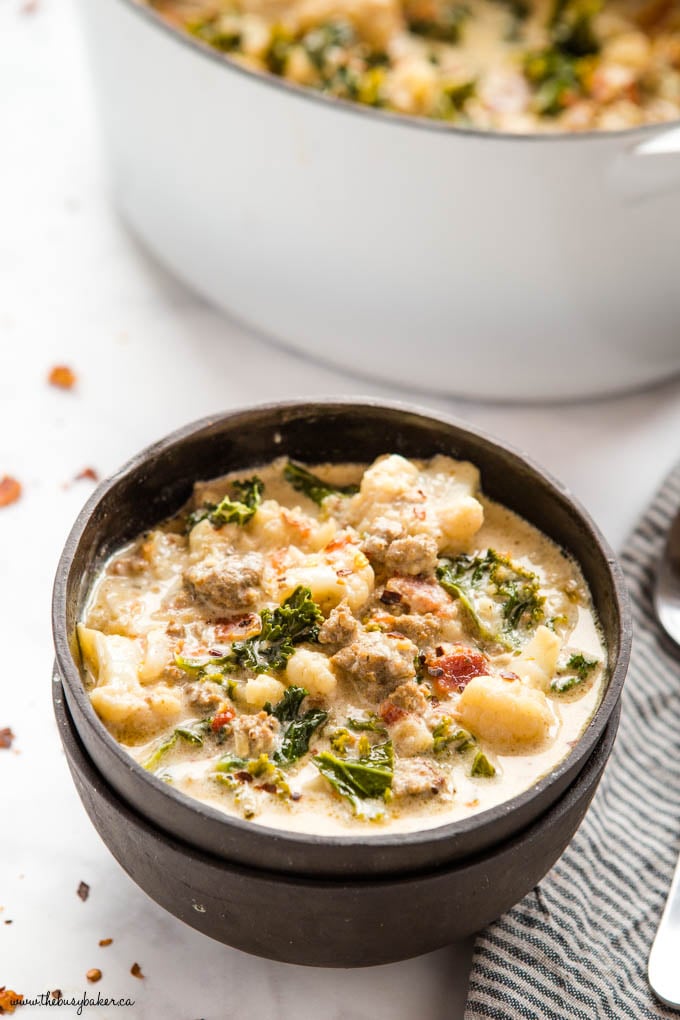 keto zuppa toscana in black bowl with kale, bacon and cauliflower
