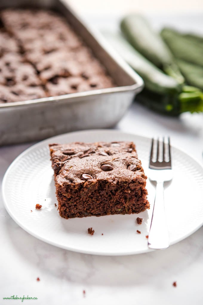 slice of moist zucchini chocolate cake on white plate with fork