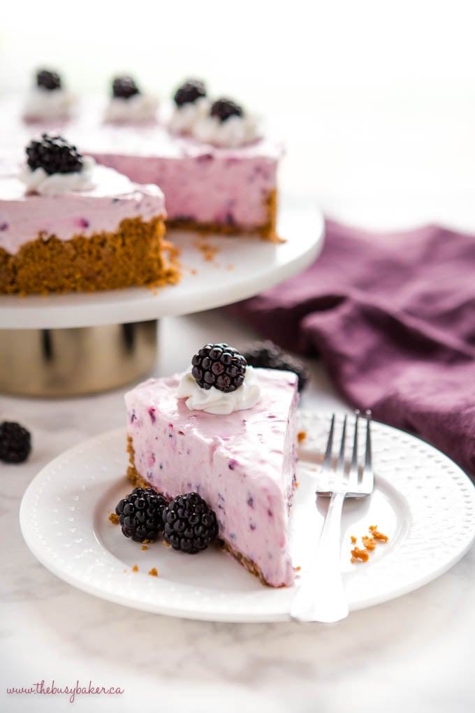 slice of blackberry cheesecake with whole cheesecake in the background