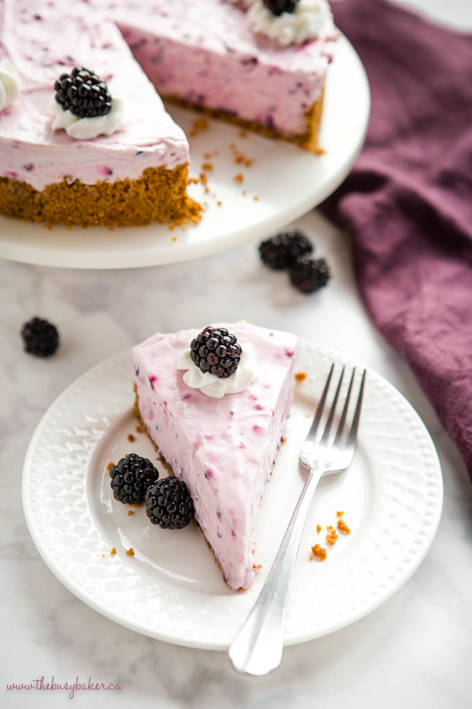 slice of cheesecake with blackberries on white plate with fork