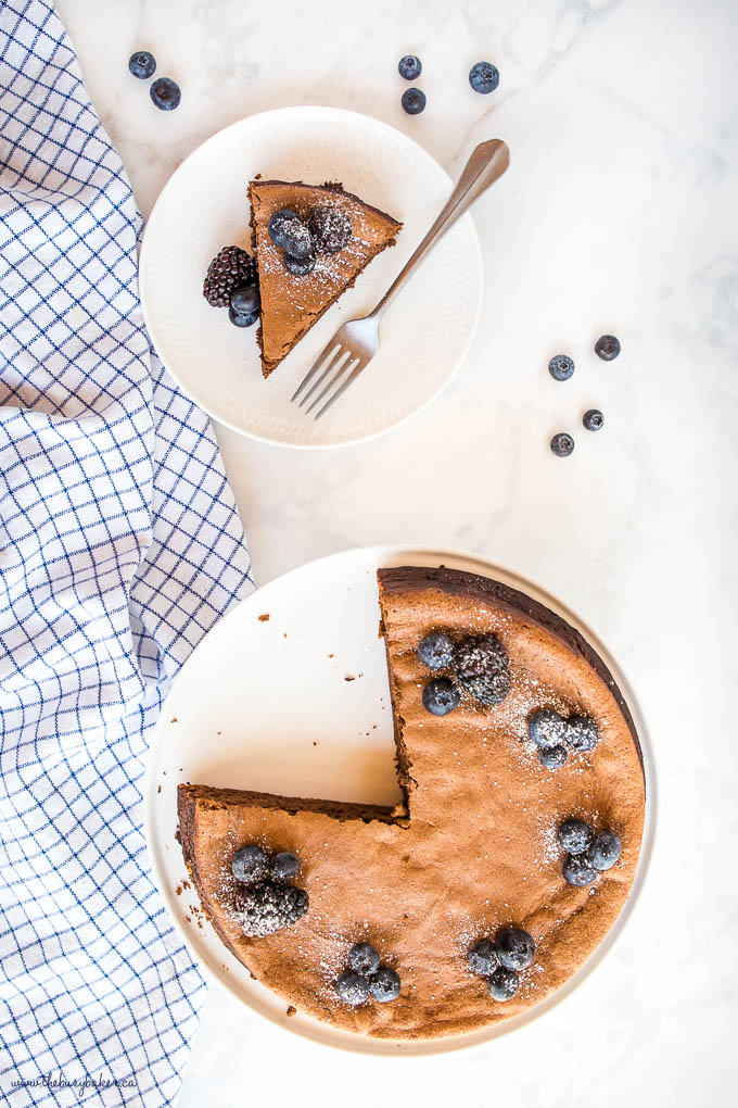 overhead image: keto flourless chocolate cake with blueberries and blackberries