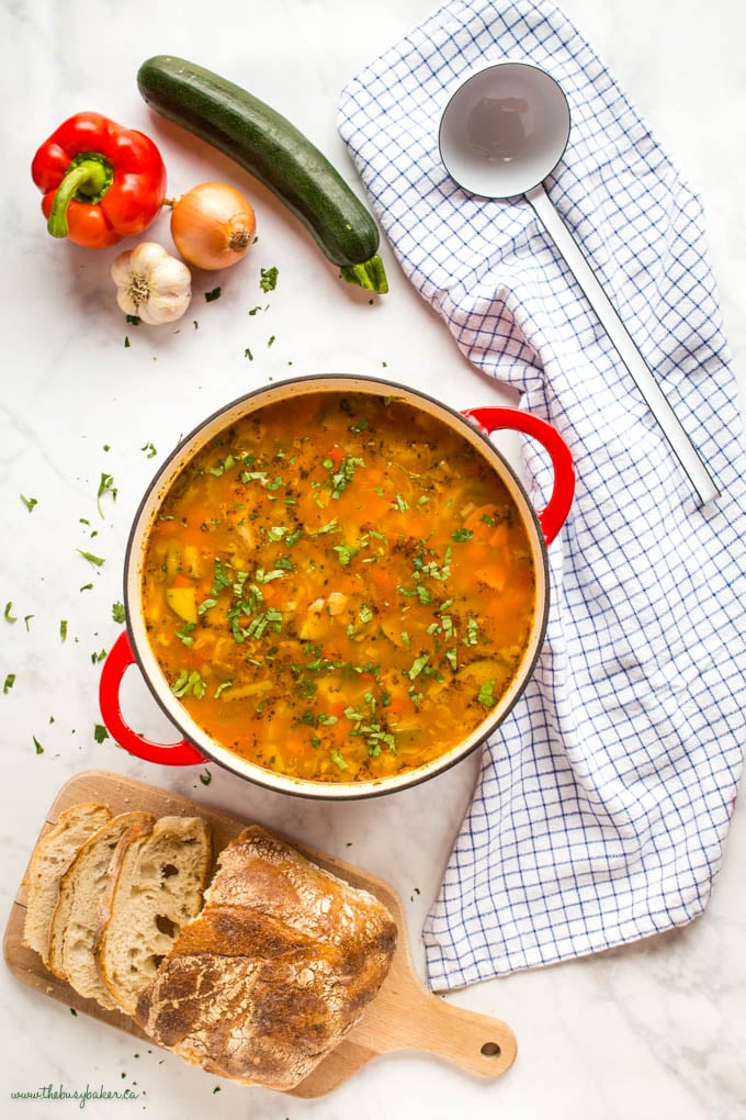 overhead image: vegetable soup with fresh herbs in red cast iron pot