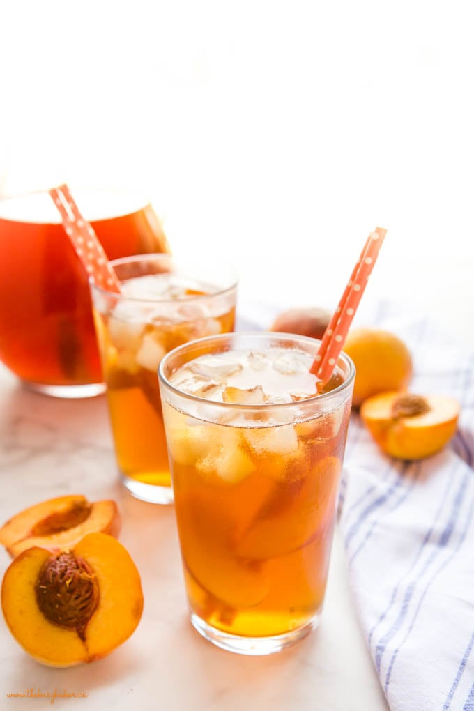 peach tea in glass with ice and paper straws