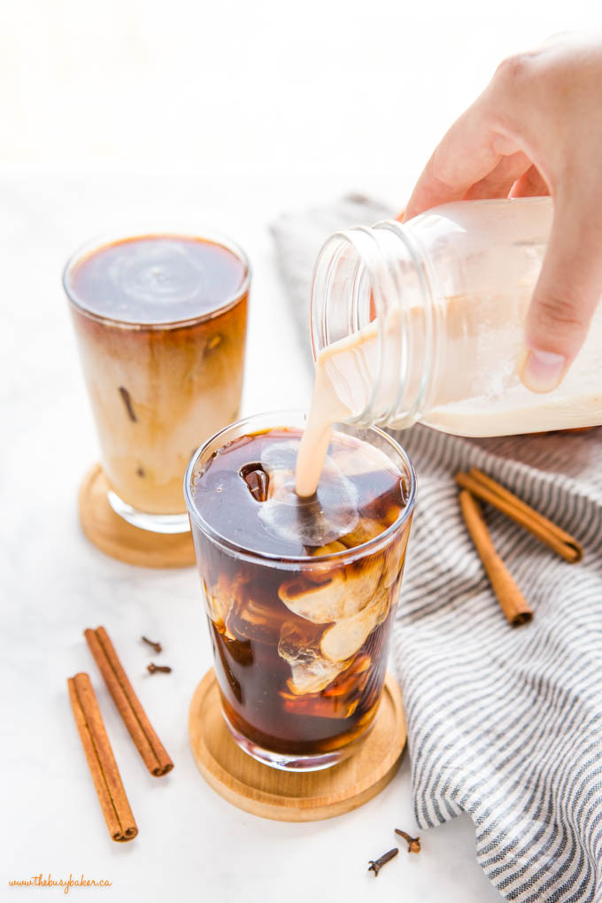 pouring sweet pumpkin cream over cold brew coffee