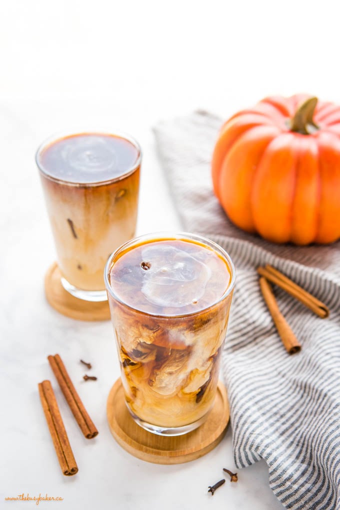 This Starbucks Pumpkin Cream Cold Brew is the perfect pumpkin spice iced coffee drink - easy-to-make cold brew coffee sweetened with a simple pumpkin cream made in a mason jar! Skip the coffee shop and make your favourite Pumpkin Cream Cold Brew at home! Recipe from thebusybaker.ca! #pumpkincreamcoldbrew #pumpkinspicelatte #pumpkinspice #pumpkin #fall #easytomake #coffee #homemade #starbucks #copycat pumpkin cream cold brew coffee in tall glass