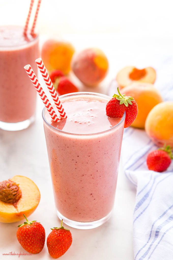 strawberry peach smoothie in glass with red chevron paper straws