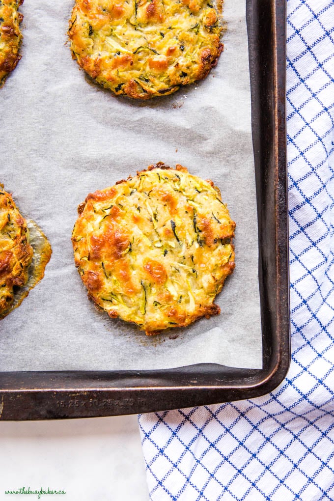 baked zucchini fritter on parchment lined baking sheet