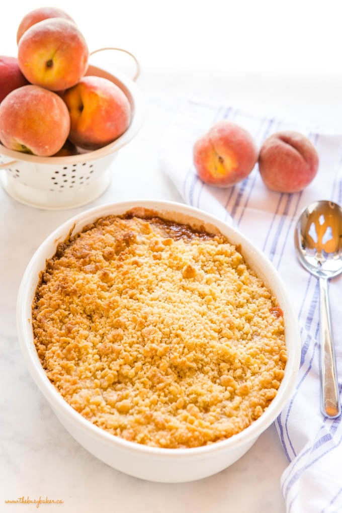 peach crumble with golden brown topping and fresh peaches
