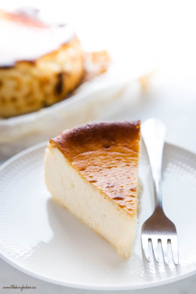 slice of san sebastian cheesecake on white plate with fork