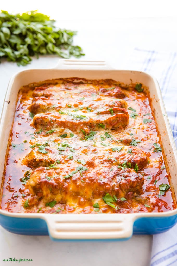 blue baking dish with stuffed sausages in marinara sauce with cheese