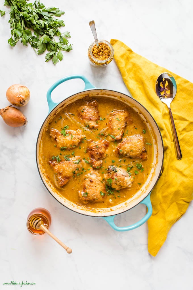 overhead image: honey mustard chicken thighs in blue cast iron skillet