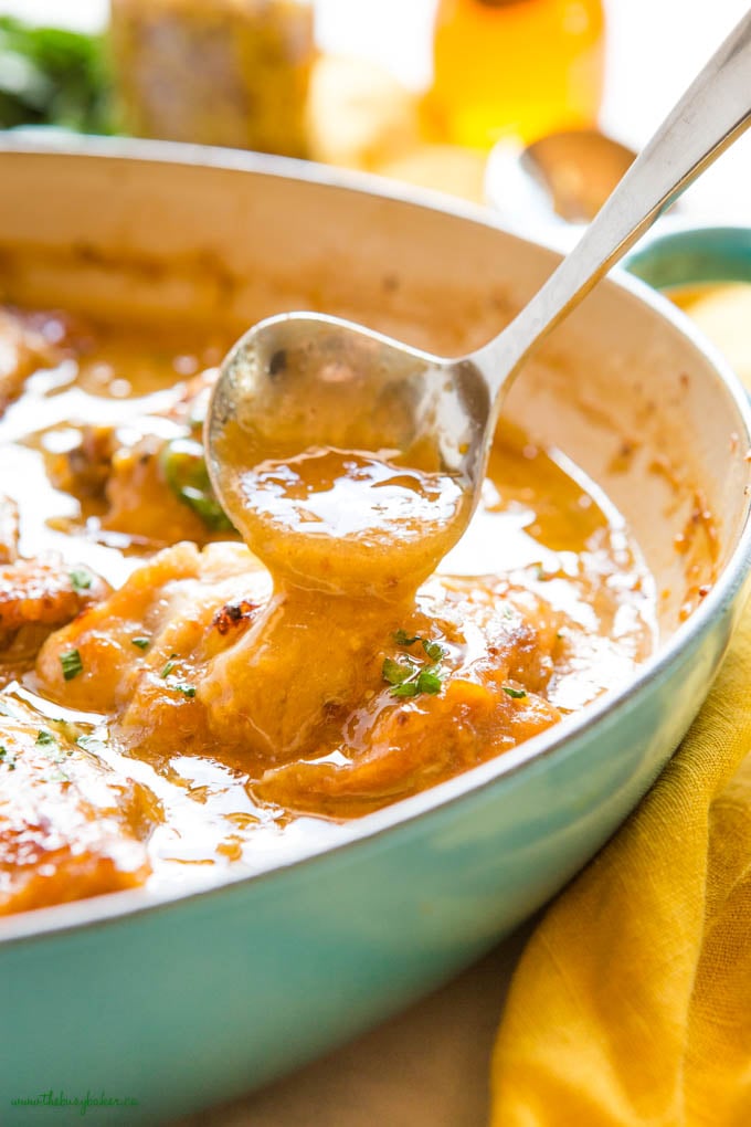 honey mustard sauce pouring over roast chicken thighs