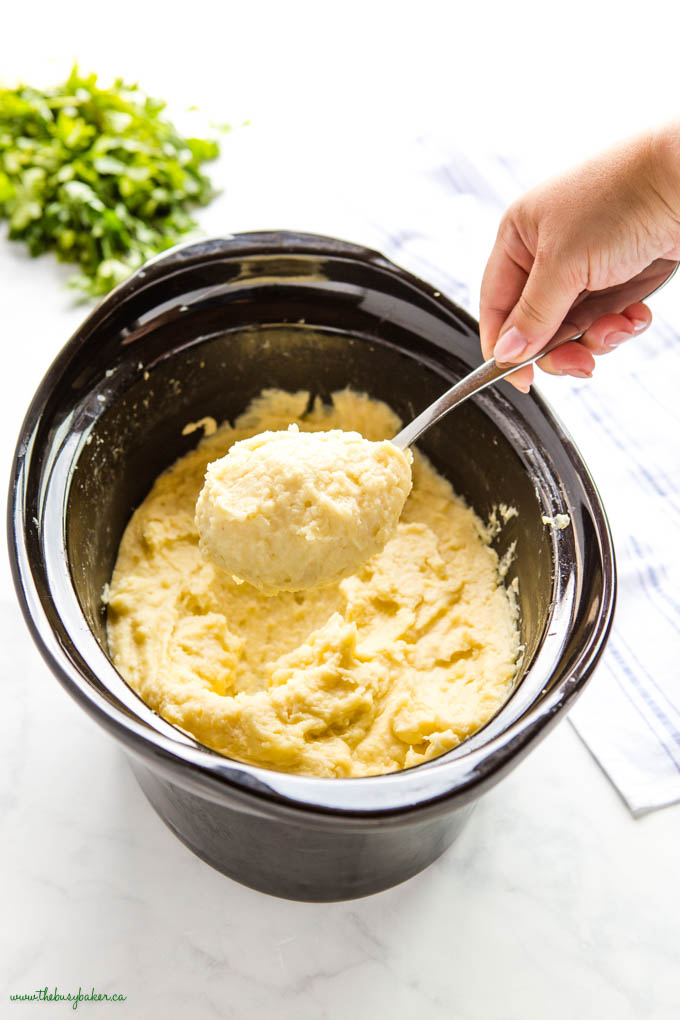 hand holding spoonful of slow cooker mashed potatoes