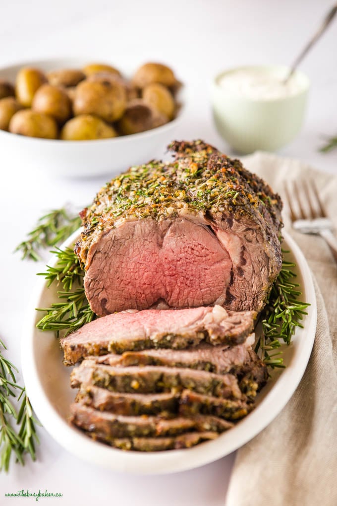 medium rare boneless beef ribeye roast prime rib on white platter