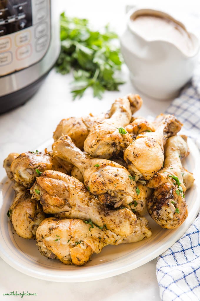 platter of roast chicken drumsticks with gravy in gravy boat