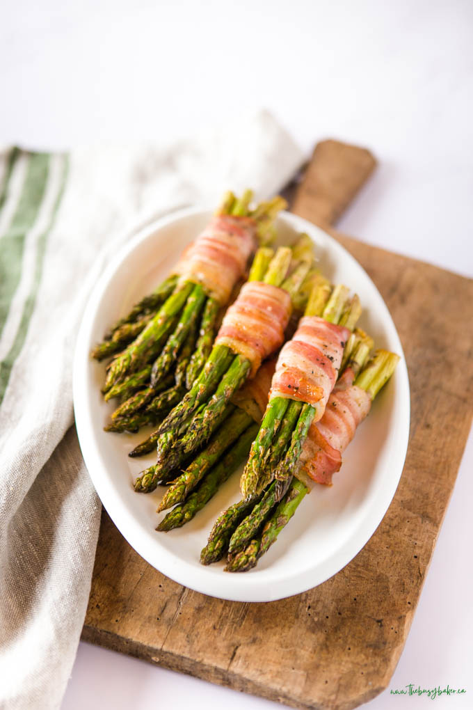 wrapped asparagus with bacon on white oval platter