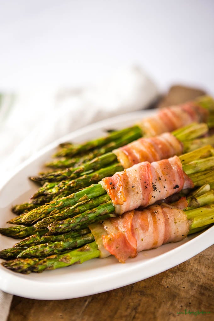 bacon wrapped asparagus on a white platter