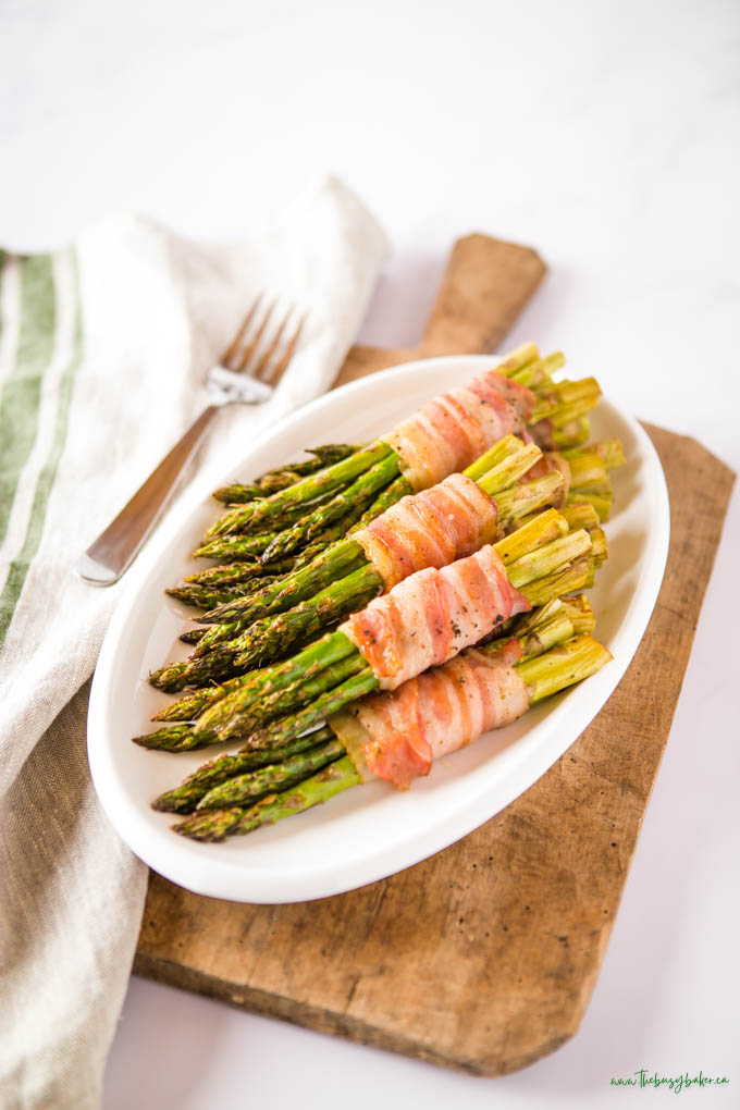 roasted wrapped asparagus with bacon on white platter