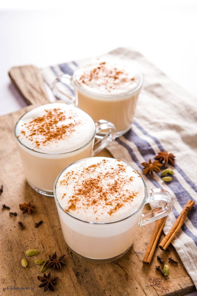 chai lattes in glass mugs with foam and cinnamon