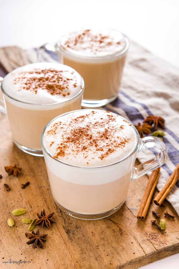 chai lattes in glass mugs with foam and cinnamon on top