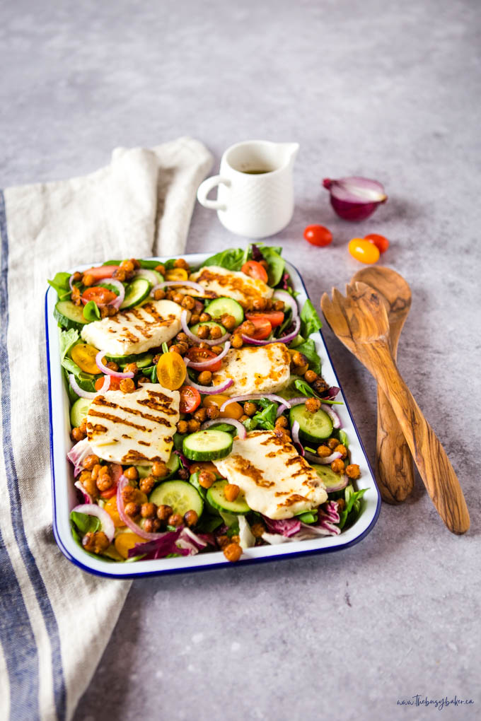 halloumi salad with veggies and roasted chickpeas on white enamel platter
