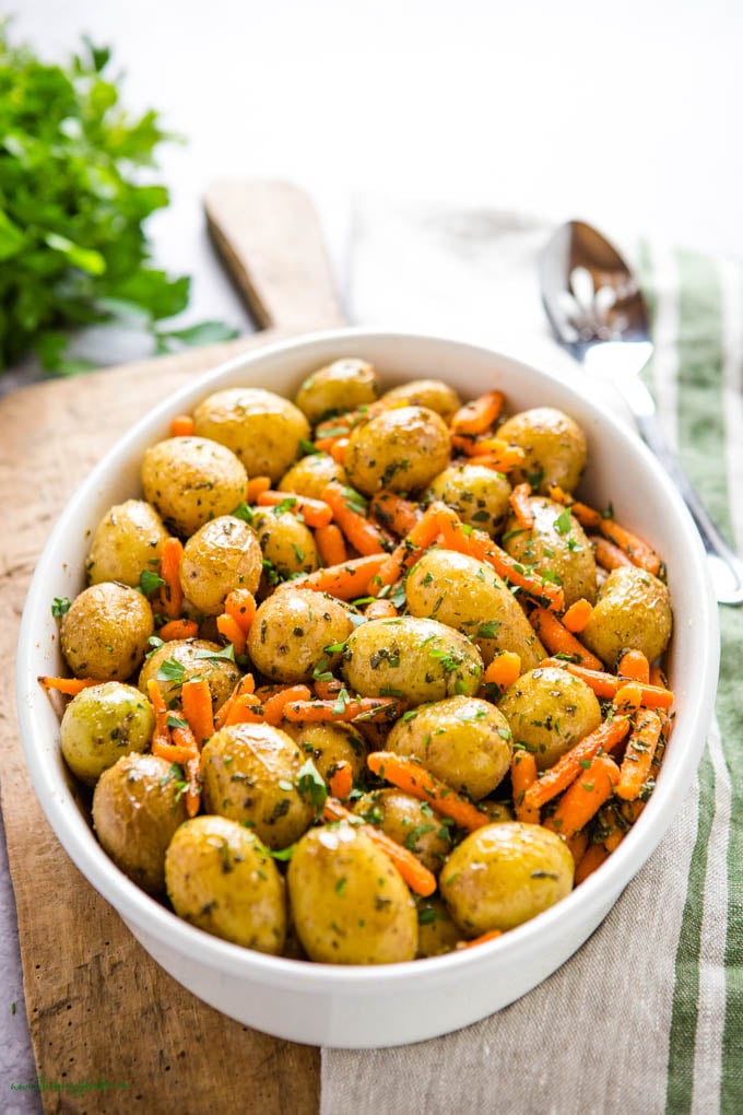 roasted potatoes and carrots in white oval baking dish