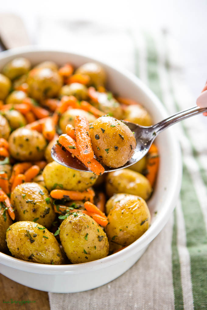 serving spoon with roasted potatoes and carrots