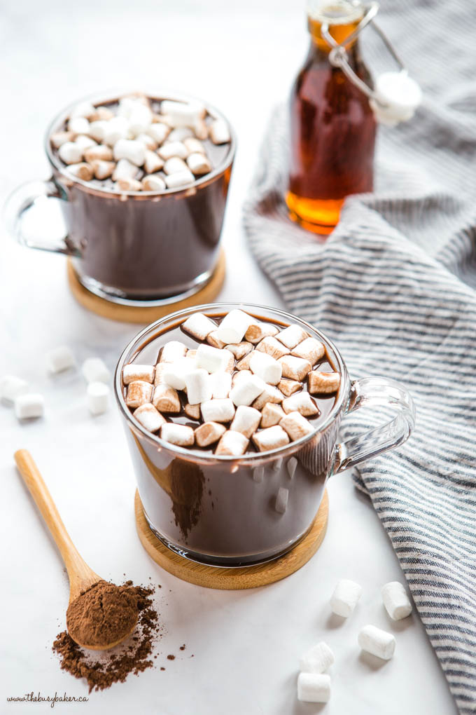 vegan hot chocolate in glass mug with vegan marshmallows and maple syrup