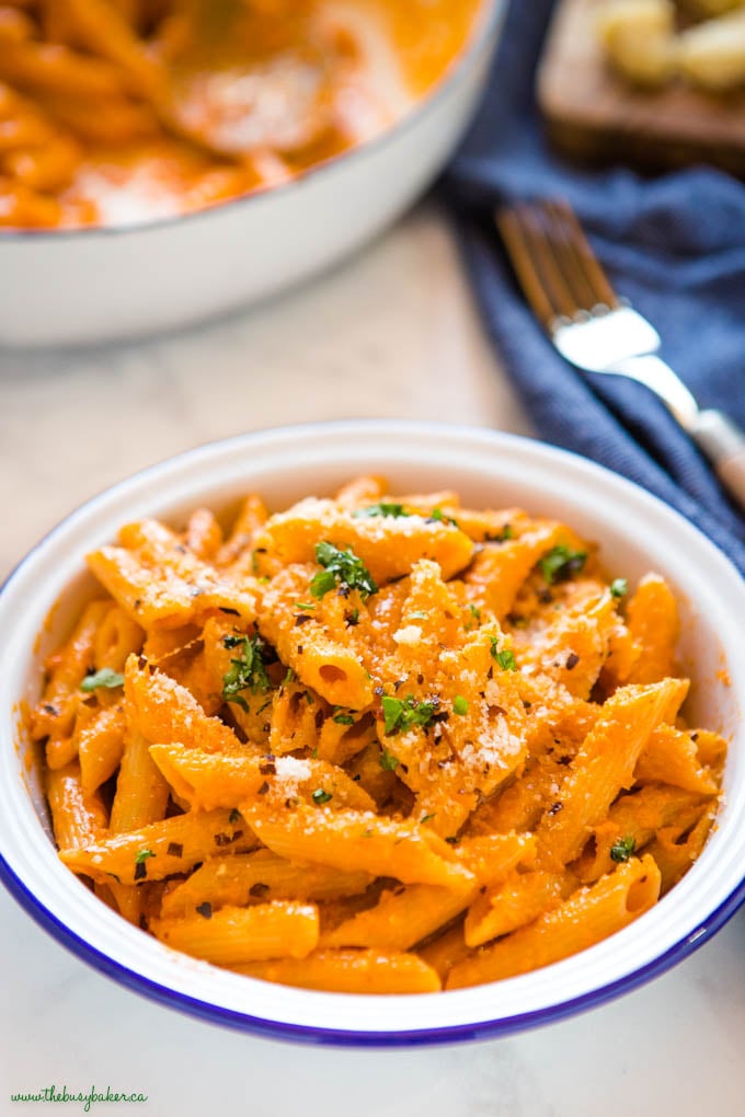 penne alla vodka in white enamel bowl with blue rim